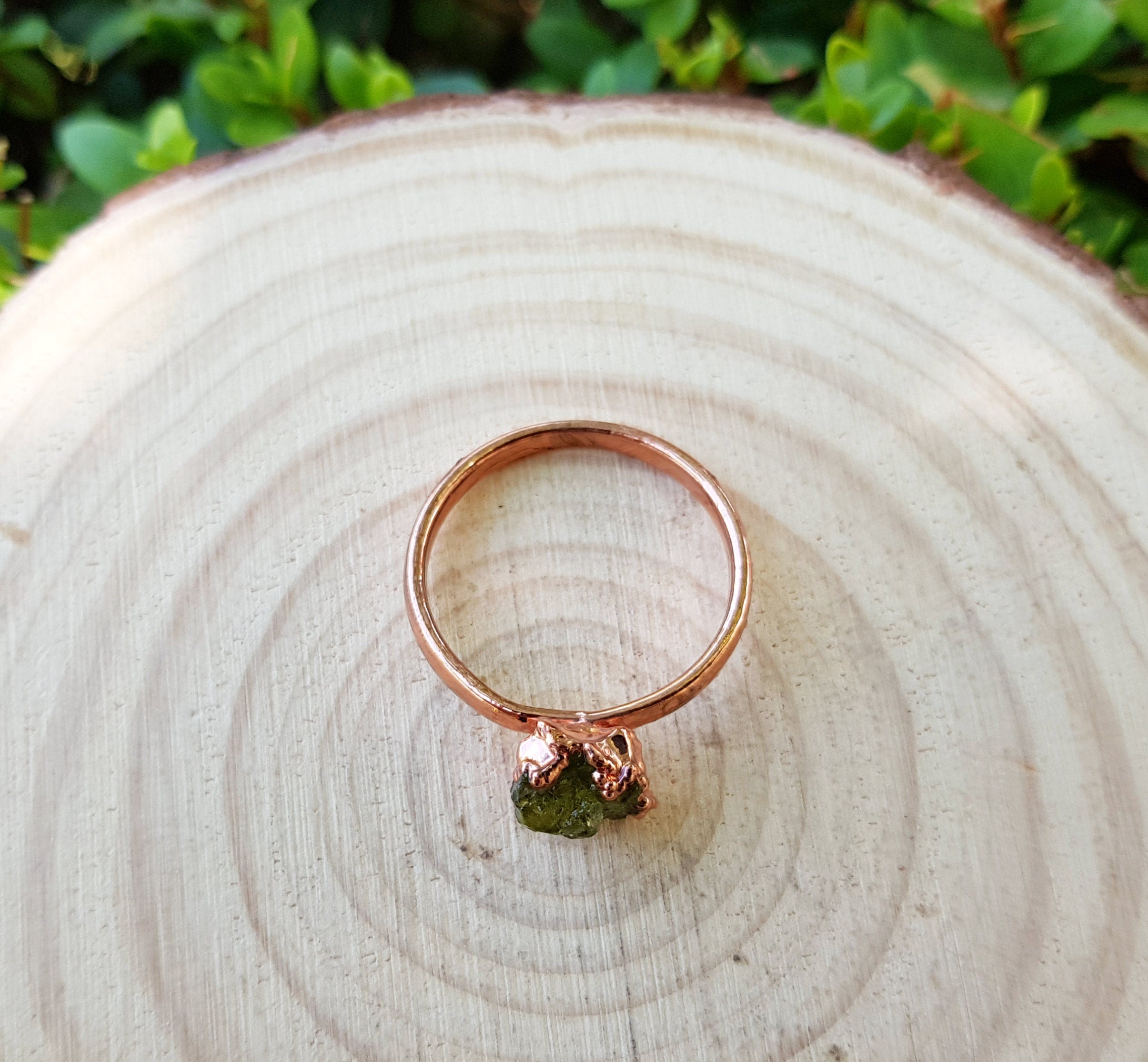 Partially cut fluorite stone ring and small raw 2024 peridot in copper or silver layer